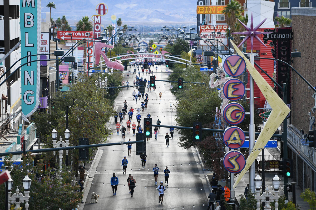 Participants head towards the finish line on Fremont Street during the Las Vegas Marathon Sunda ...