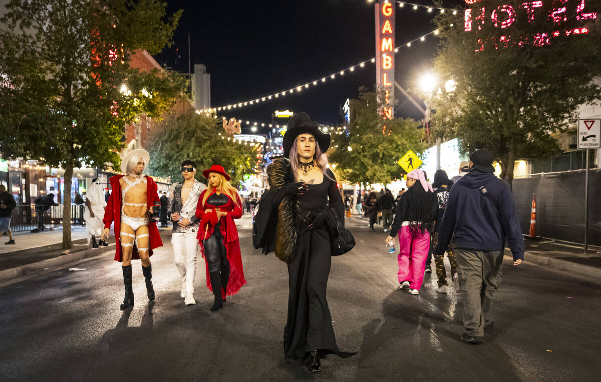 People walk along Fremont Street during Halloween night on Thursday, Oct. 31, 2024, in Las Vega ...