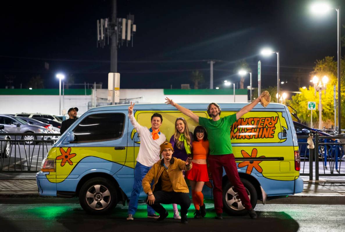 A group dressed as characters from Scooby-Doo poses with the Mystery Machine van on Ogden Avenu ...