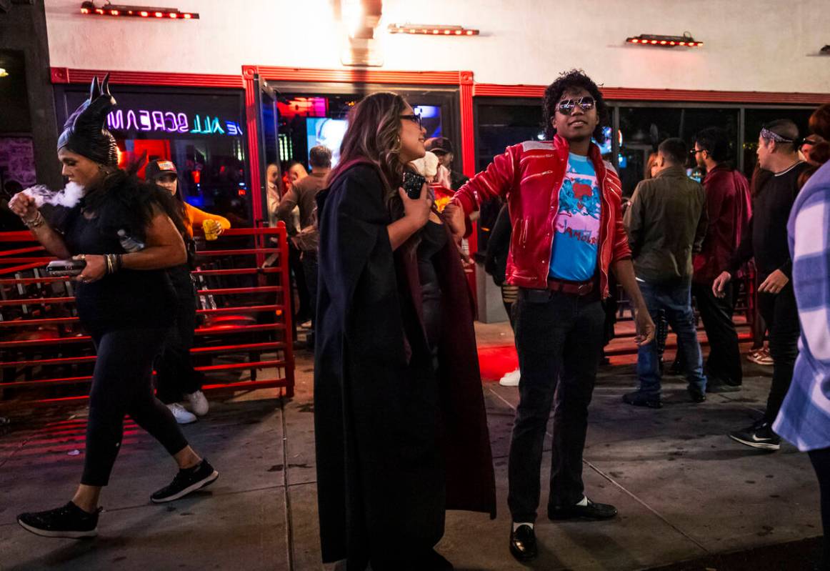 A man dressed as Michael Jackson looks on along Fremont Street during Halloween night on the ea ...