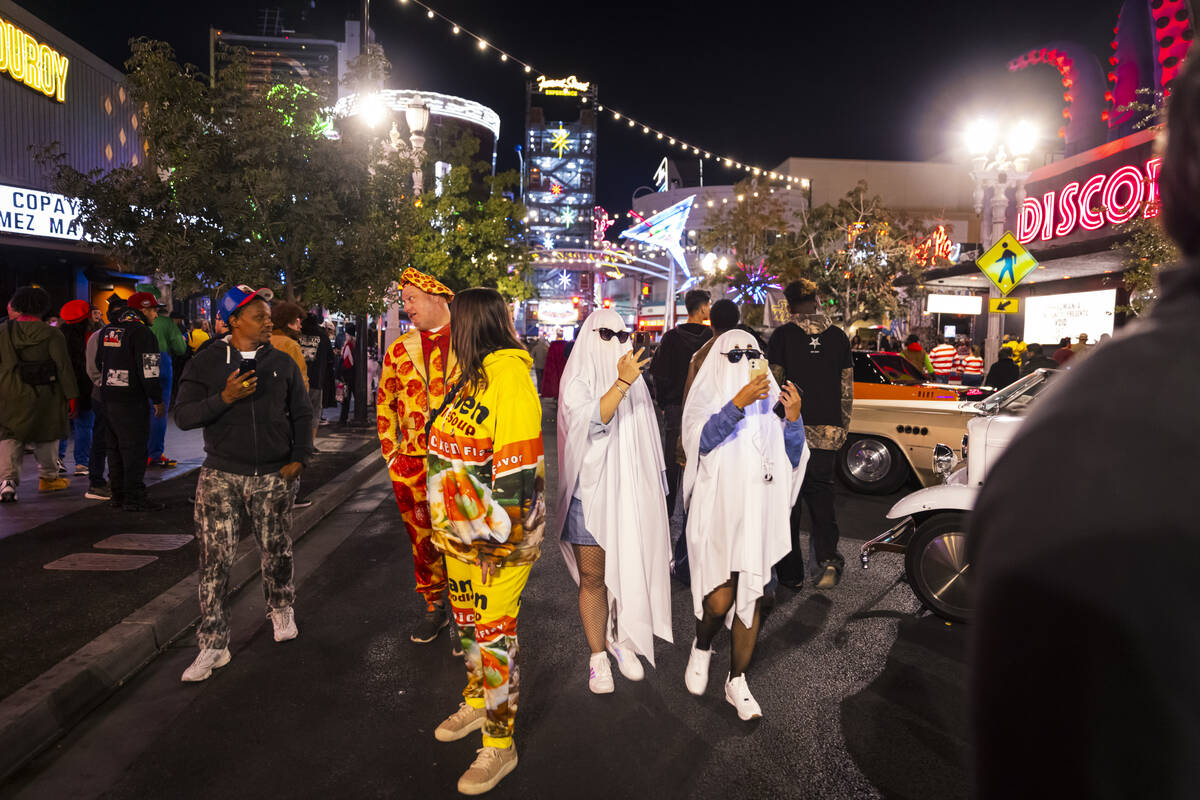 People walk along Fremont Street during Halloween night on Thursday, Oct. 31, 2024, in Las Vega ...