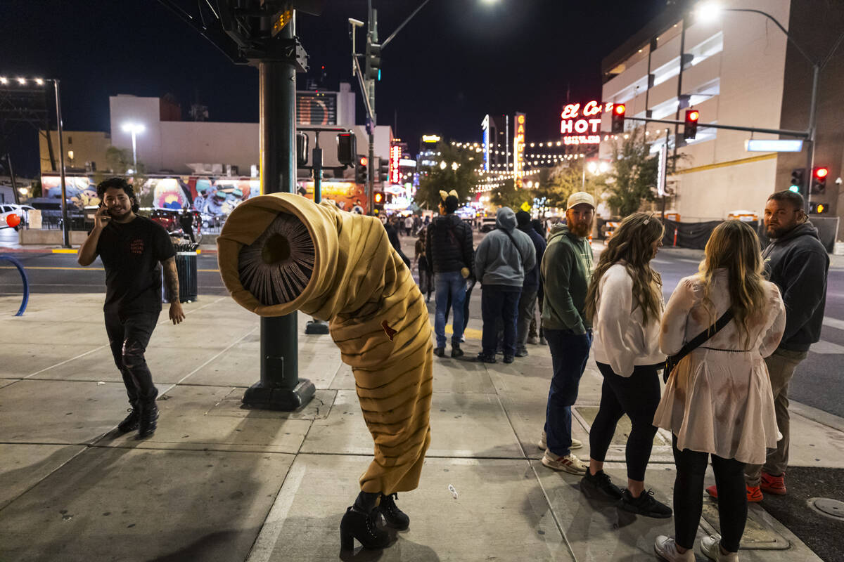 A woman in a sandworm costume poses along Fremont Street during Halloween night on Friday, Nov. ...