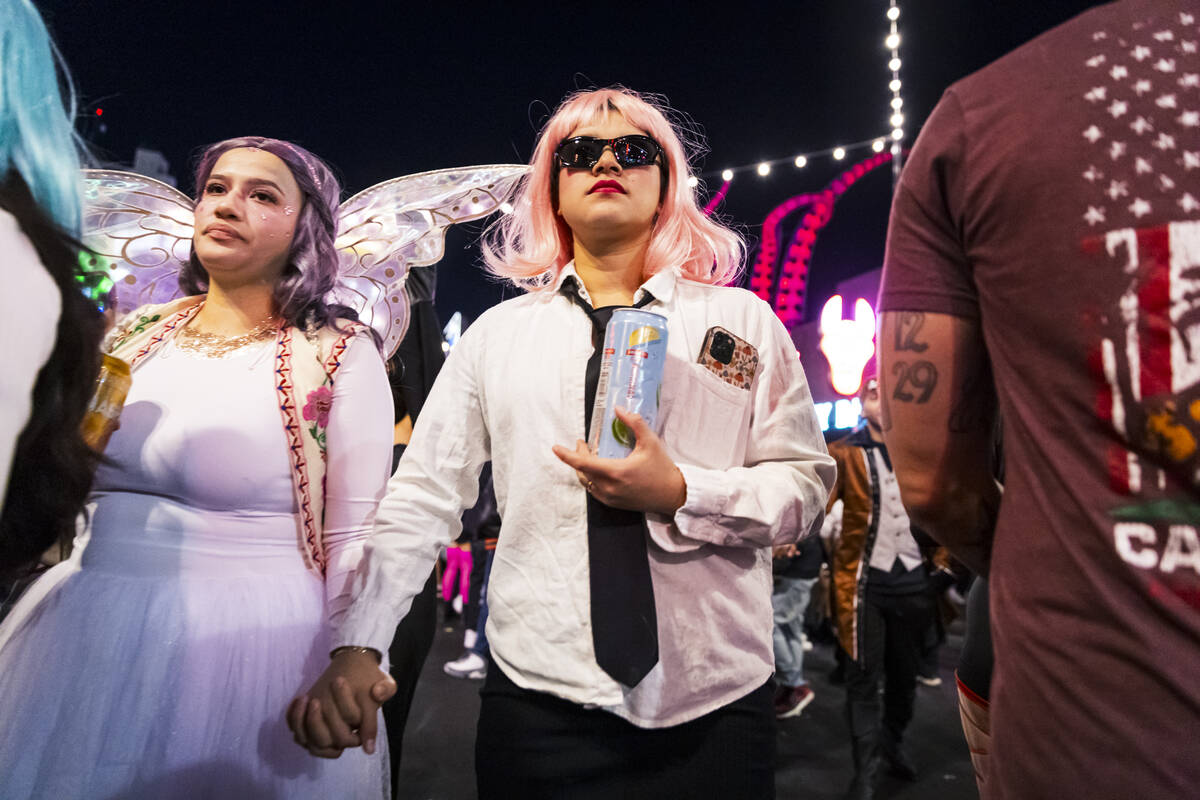 People walk along Fremont Street during Halloween night on Thursday, Oct. 31, 2024, in Las Vega ...