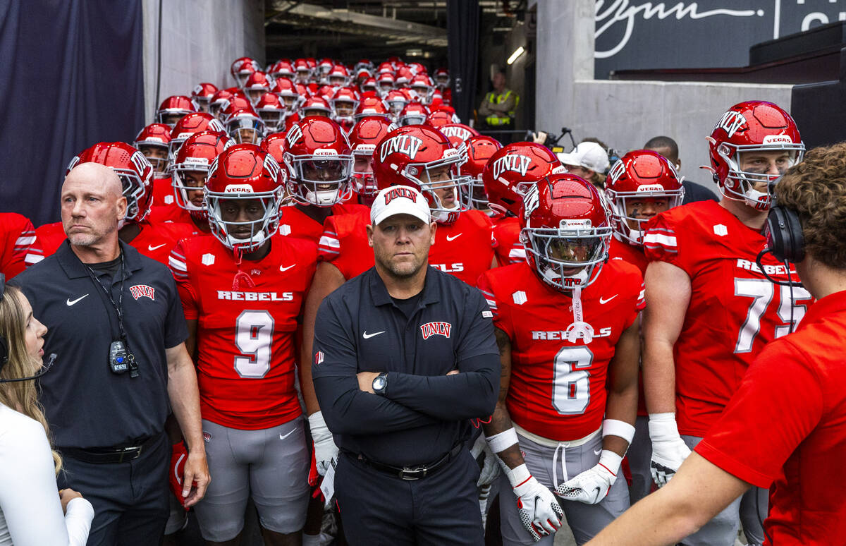 UNLV Head Coach Barry Odom and players await introduction as the ready to face the Fresno State ...