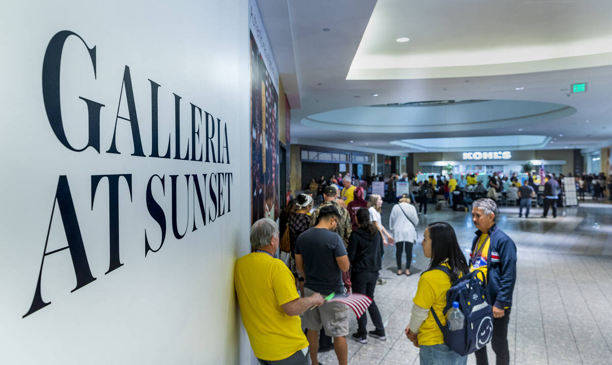 The last voters stand in line to cast their ballots in a polling spot in the Galleria at Sunset ...