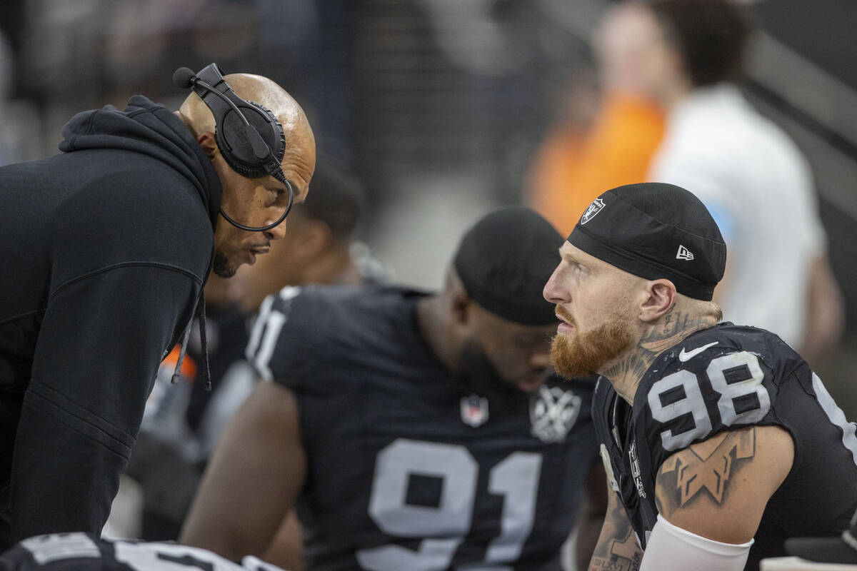 Raiders head coach Antonio Pierce speaks with Raiders defensive end Maxx Crosby (98) on the sid ...