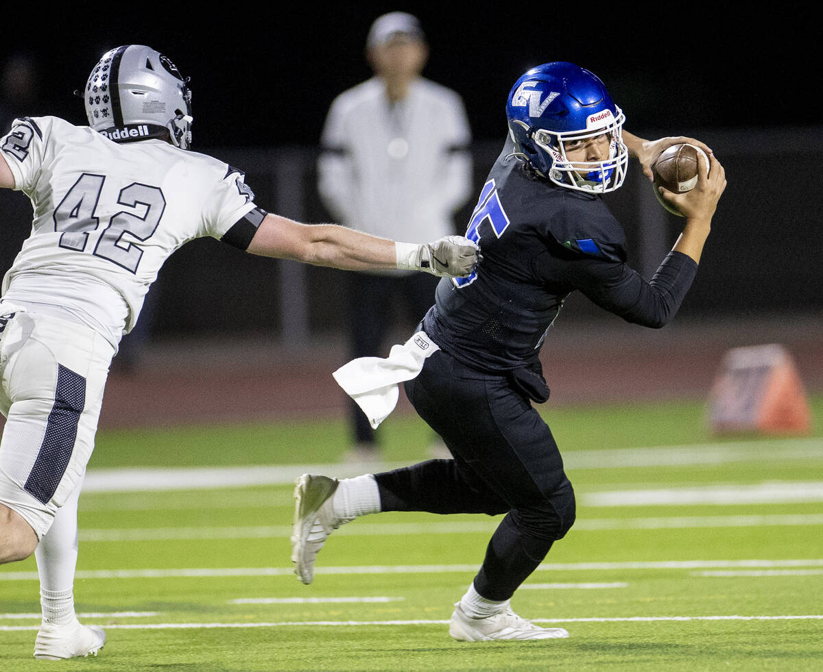 Green Valley quarterback Michael Lewis (15) avoids Palo Verde junior Owen Anderson (42) during ...