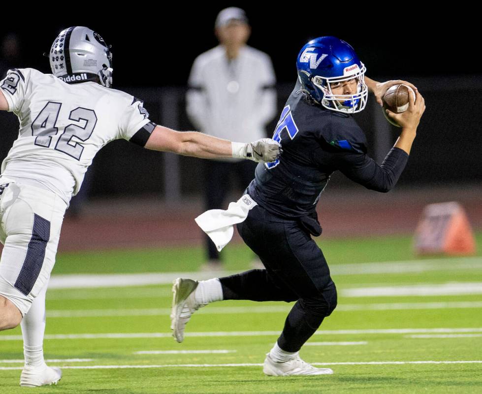 Green Valley quarterback Michael Lewis (15) avoids Palo Verde junior Owen Anderson (42) during ...