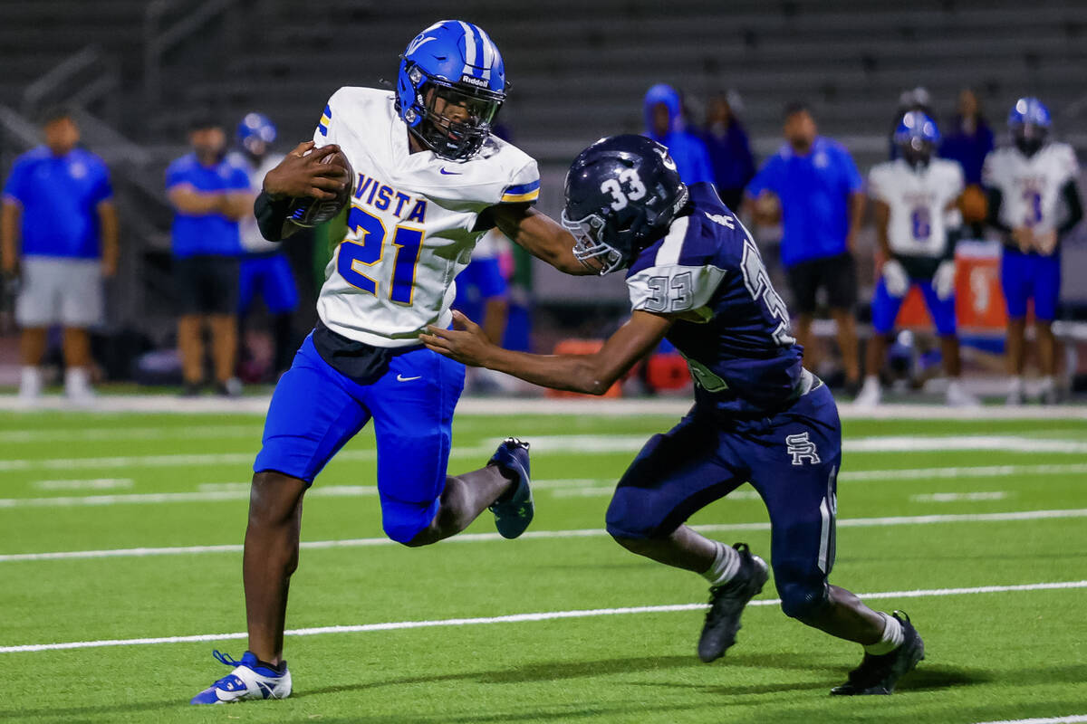 Sierra Vista running back Christian Lee (21) stiff arms Shadow Ridge safety Mujahid Gilliard (3 ...