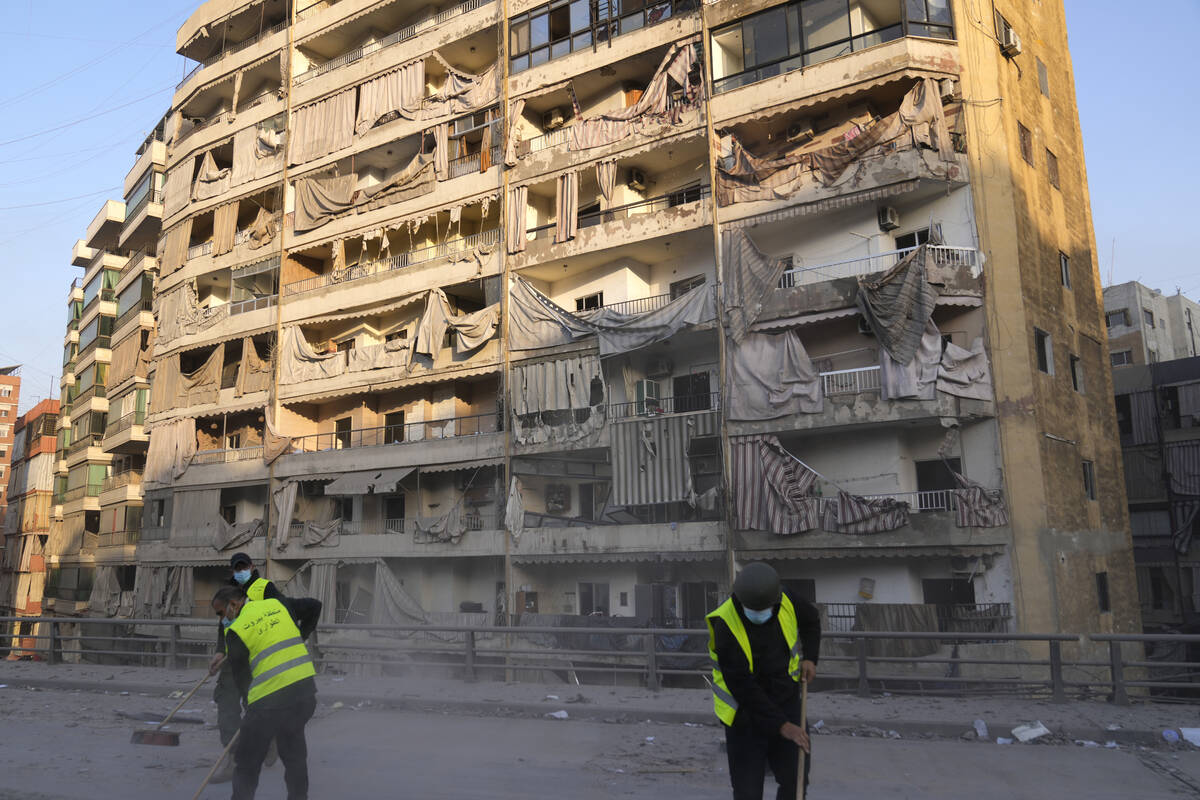 Workers remove the rubble in front of a damaged building that was hit by an Israeli airstrike o ...