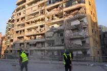 Workers remove the rubble in front of a damaged building that was hit by an Israeli airstrike o ...