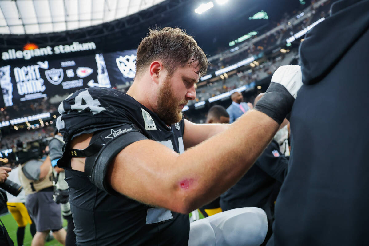 Raiders offensive tackle Kolton Miller (74) joins a prayer circle following an NFL football gam ...