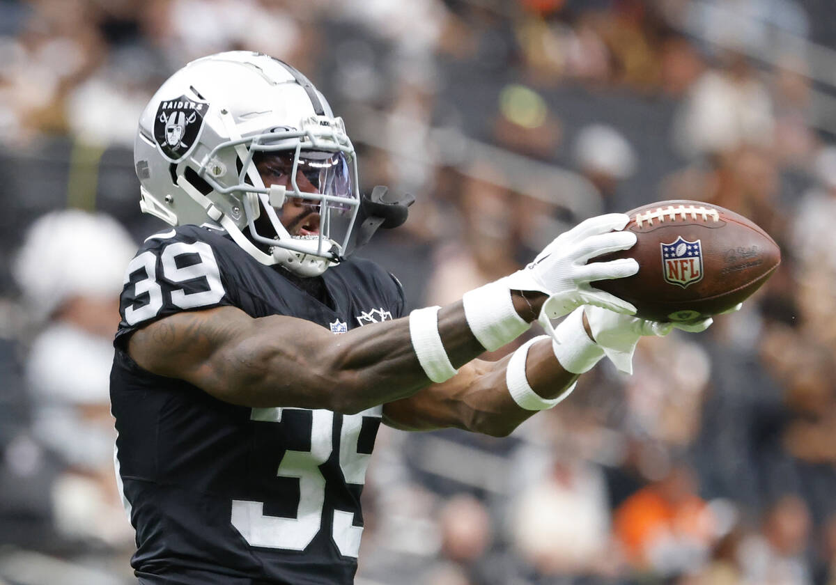 Raiders cornerback Nate Hobbs (39) catches the ball as he warms up before an NFL game against ...