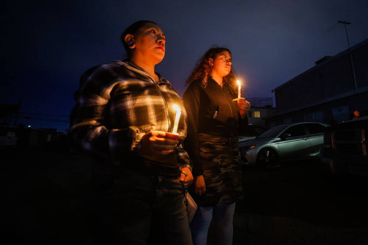 Mourners hold onto candles during a vigil for 17-year-old Jonathan Lewis on the one-year annive ...