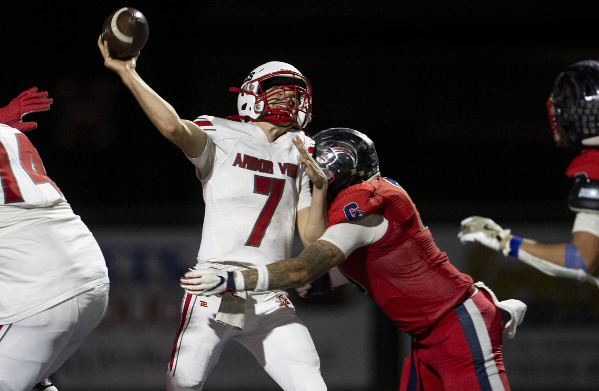 Arbor View quarterback Thaddeus Thatcher (7) is hit while throwing the ball during the high sch ...