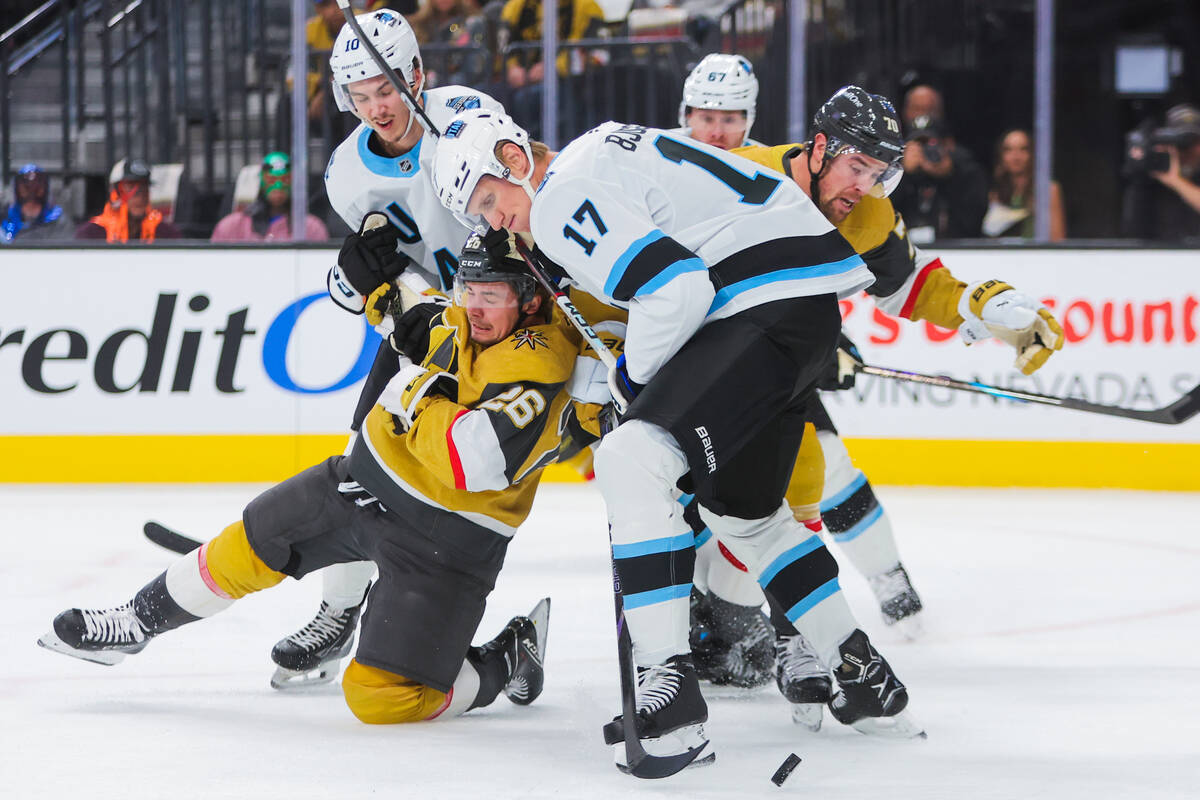 Golden Knights right wing Alexander Holtz (26) loses his balance in a race for the puck with Ut ...