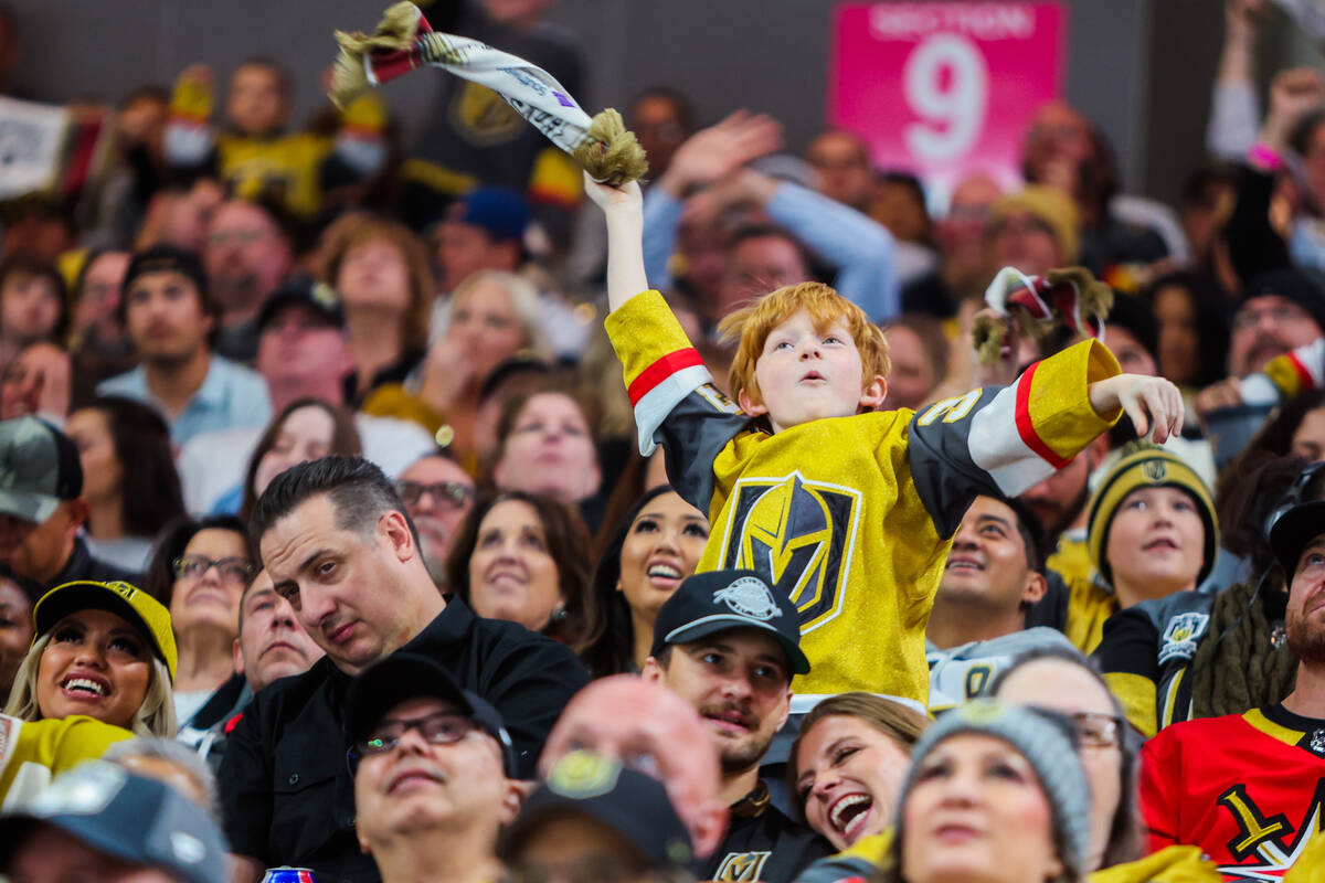 A young Golden Knights fan cheers for his team during an NHL hockey game between the Golden Kni ...