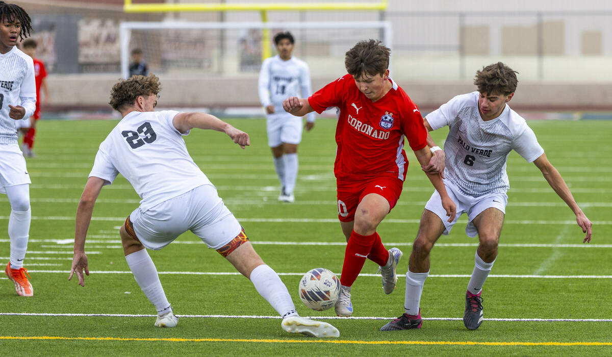 Coronado midfielder Aiden Sena (10) splits the defense of Palo Verde defender Ben Legrand (23) ...