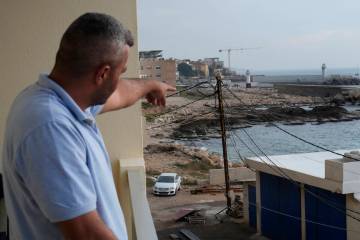 A Lebanese man points to the beach in Batroun, northern Lebanon, Saturday, Nov. 2, 2024, where ...