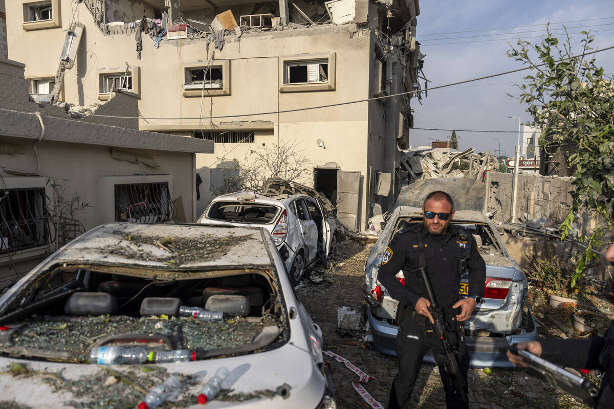 Israeli police men work at the site where projectiles fired from Lebanon hit a home in Tira, ce ...