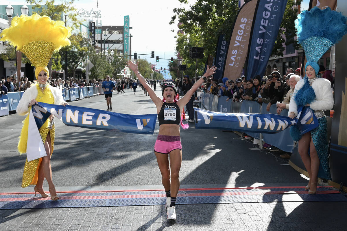 Women’s marathon first place finisher Ashley Paulson crosses the finish line during the Las V ...