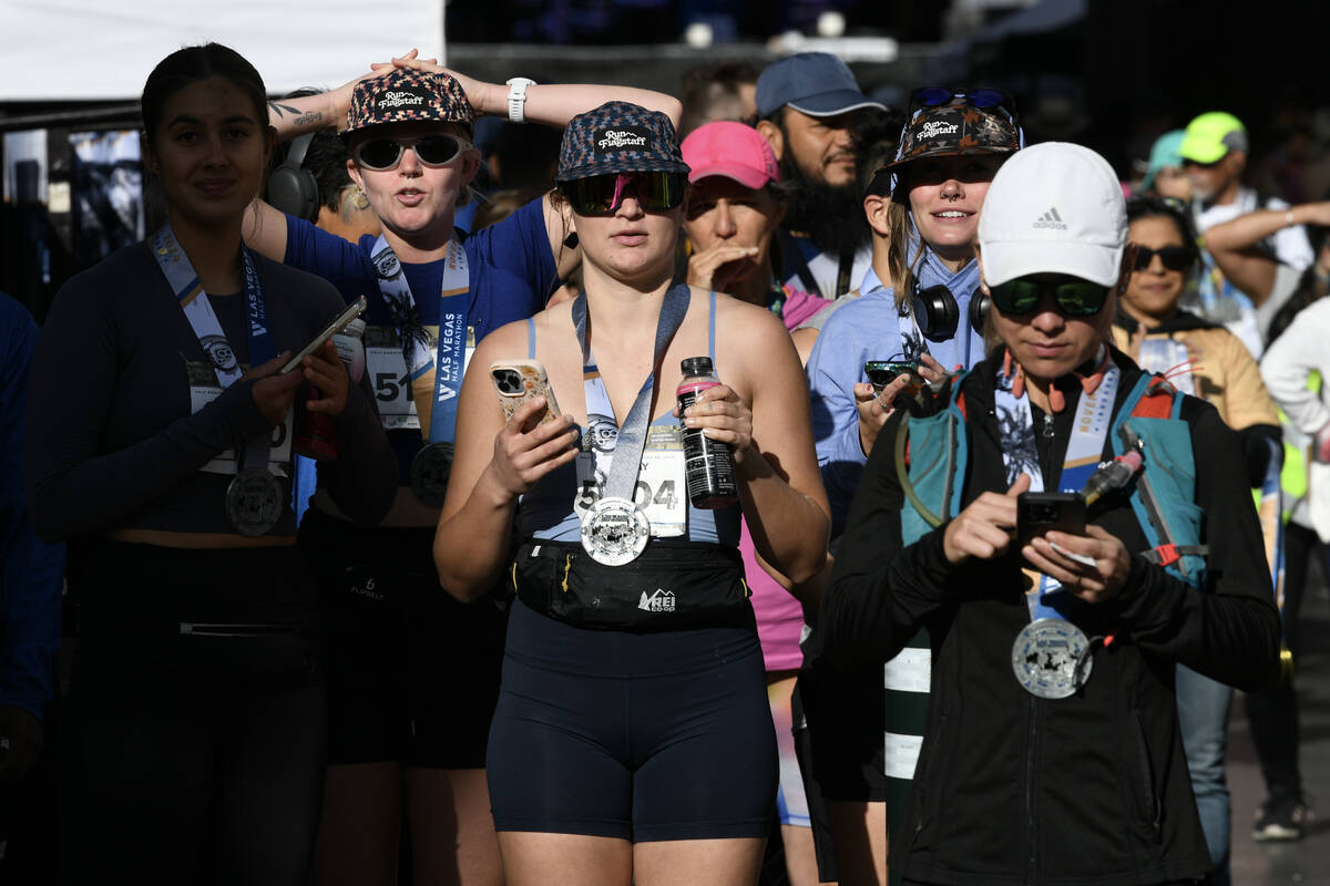 Finishers wait for fiends to cross the finish line during the Las Vegas Marathon Sunday, Nov. 3 ...