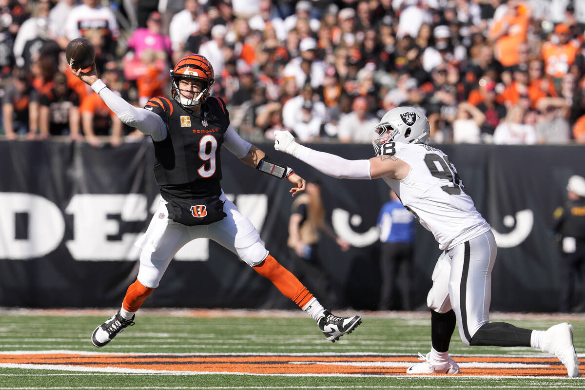 Cincinnati Bengals quarterback Joe Burrow (9) passes while pressured by Las Vegas Raiders defen ...