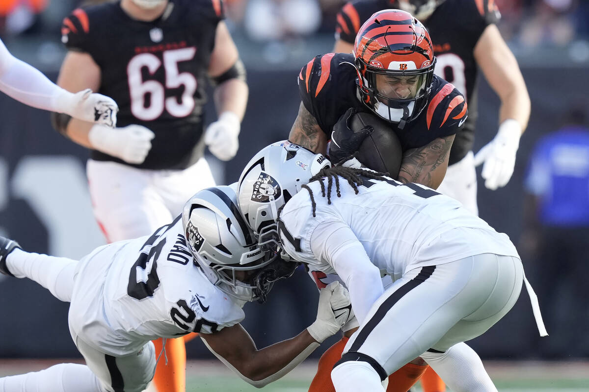 Cincinnati Bengals running back Chase Brown, top right, runs against Las Vegas Raiders safety I ...