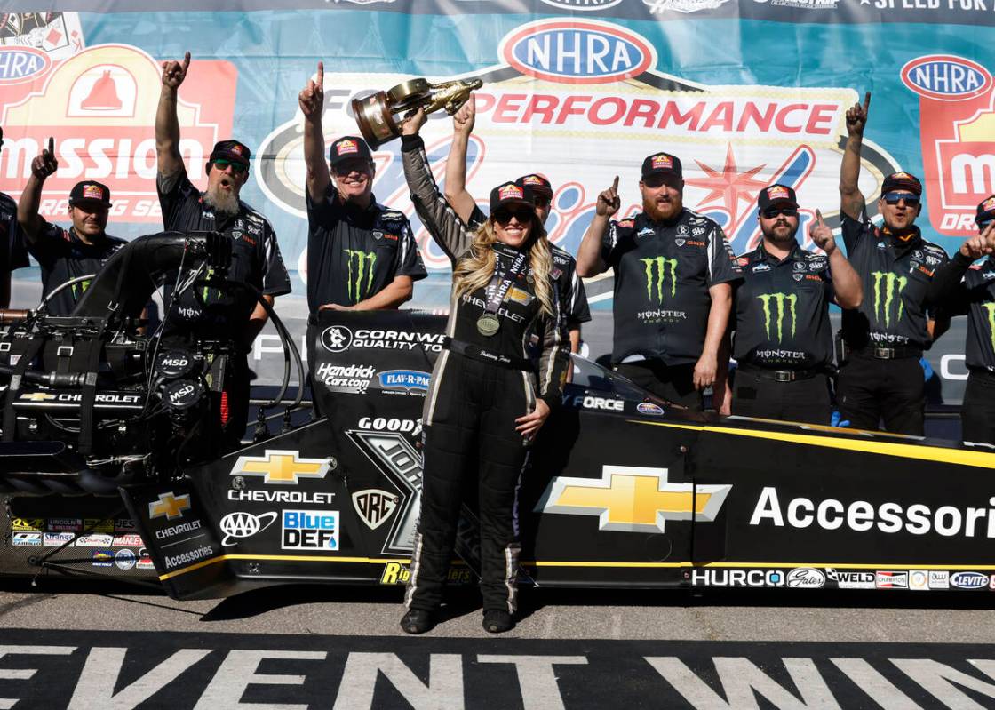 Top Fuel driver Brittany Force, center, celebrates her win following the NHRA Nationals at the ...