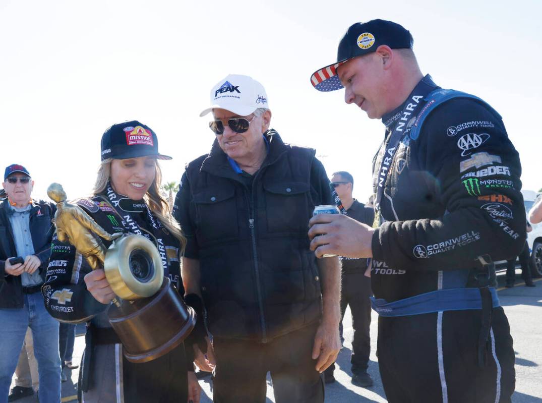 Top Fuel driver Brittany Force, left, shows her trophy to her father John after winning the NHR ...