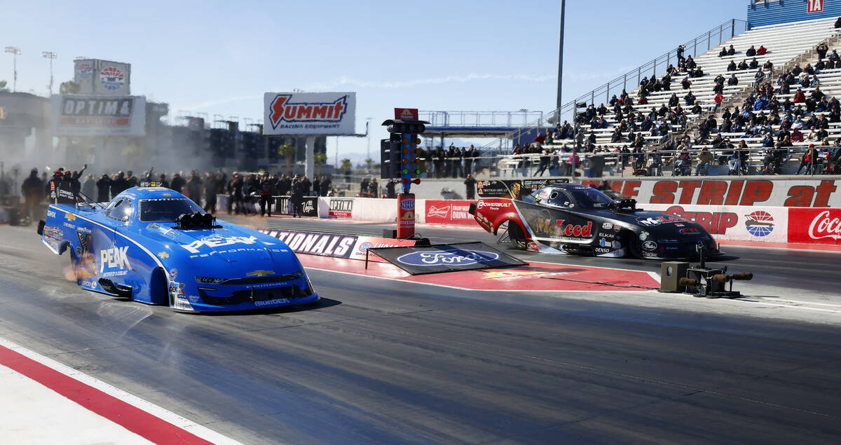 Funny car drivers Jack Beckman, left, and Paul Lee take off during the semifinals of the NHRA N ...