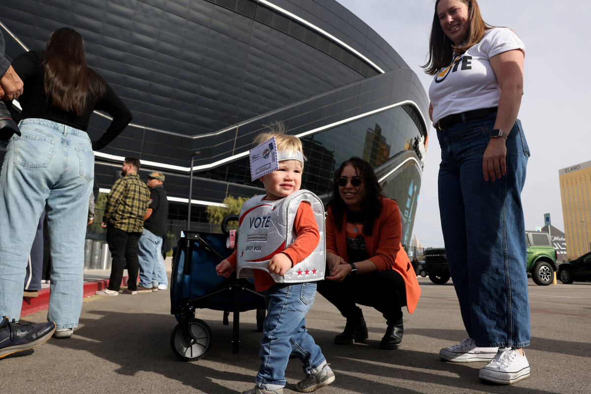 Murray, 18 months, arrives with his parents to vote at Allegiant Stadium in Las Vegas Tuesday, ...