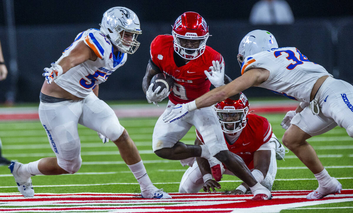 UNLV running back Jai'Den Thomas (9) looks to fend off Boise State Broncos safety Alexander Teu ...