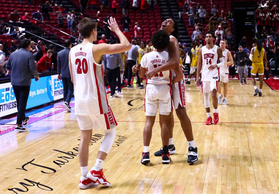 UNLV Rebels forward Jeremiah Cherry, right, hugs UNLV Rebels guard Dedan Thomas Jr. (11) after ...