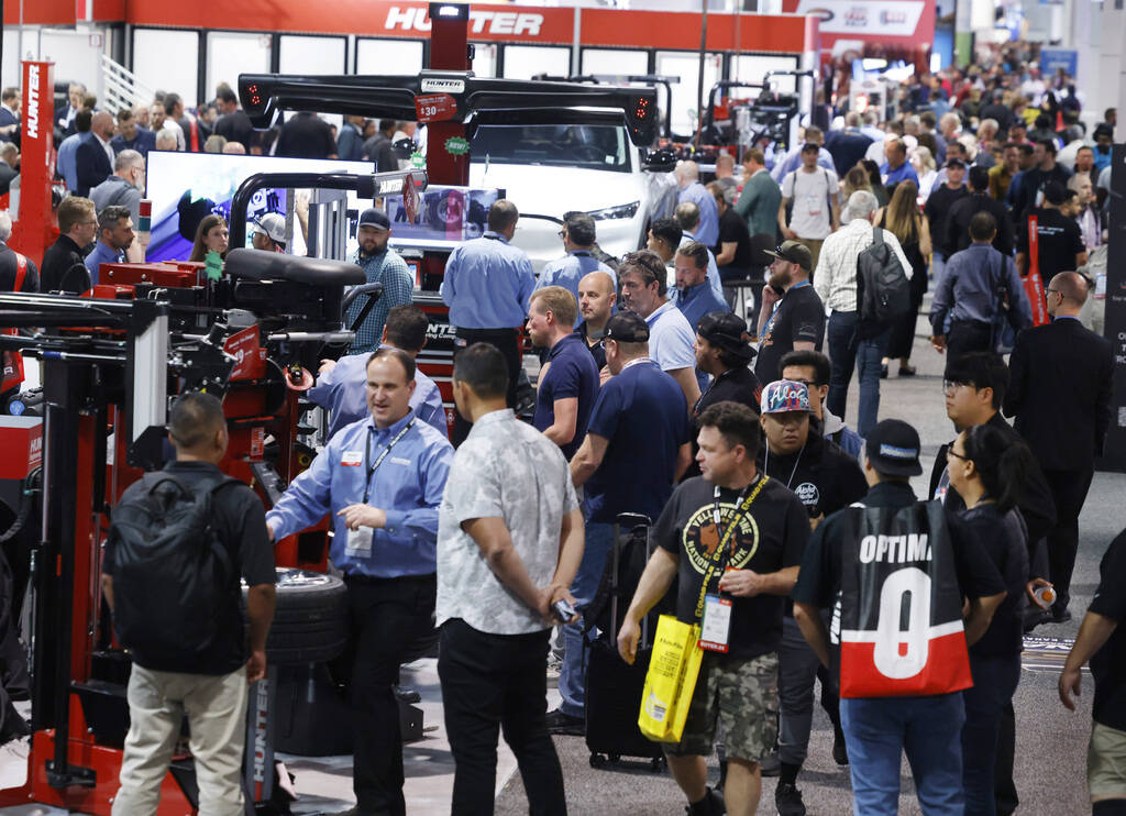 Attendees walk about and view some of the many vehicle maintenance machines by the Hunter Engin ...