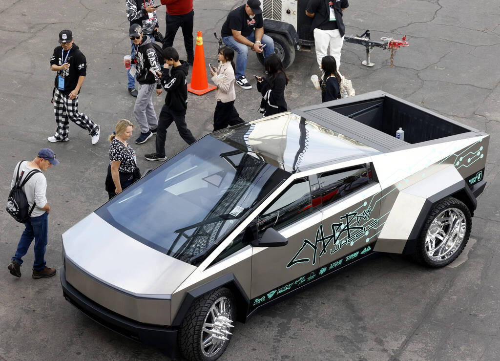 Attendees check out a Tesla Cybertruck on display during the first day of SEMA at the Las Vegas ...