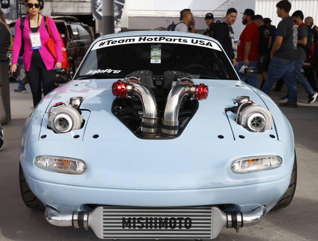 Attendees check out a custom built Mazda Miata during the first day of SEMA at the Las Vegas Co ...