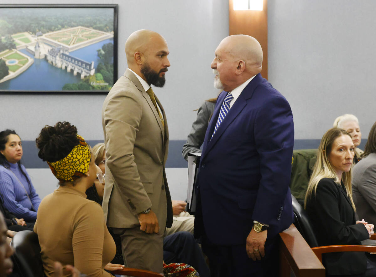 Metropolitan Police Department Sgt. Kevin Menon, left, talks with his attorney Dominic Gentile ...