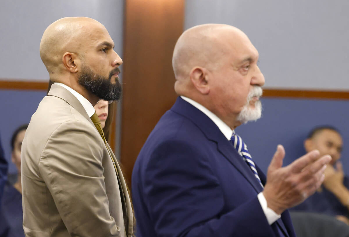 Metropolitan Police Department Sgt. Kevin Menon, left, listens as his attorney Dominic Gentile ...