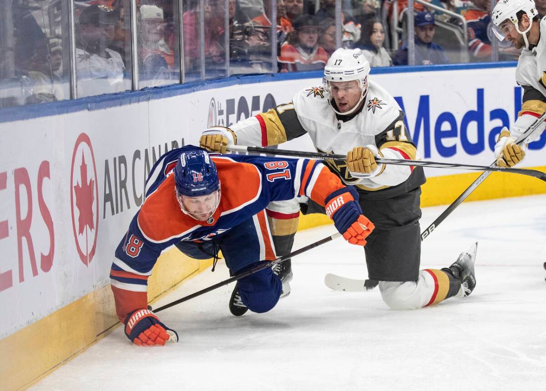 Vegas Golden Knights' Ben Hutton (17) checks Edmonton Oilers' Zach Hyman (18) during the second ...