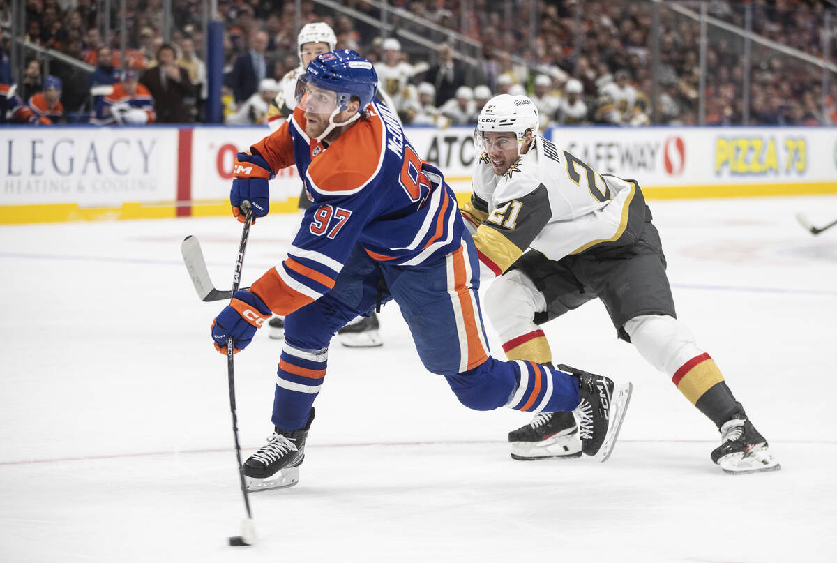 Vegas Golden Knights' Brett Howden (21) tries to defend against Edmonton Oilers' Connor McDavid ...