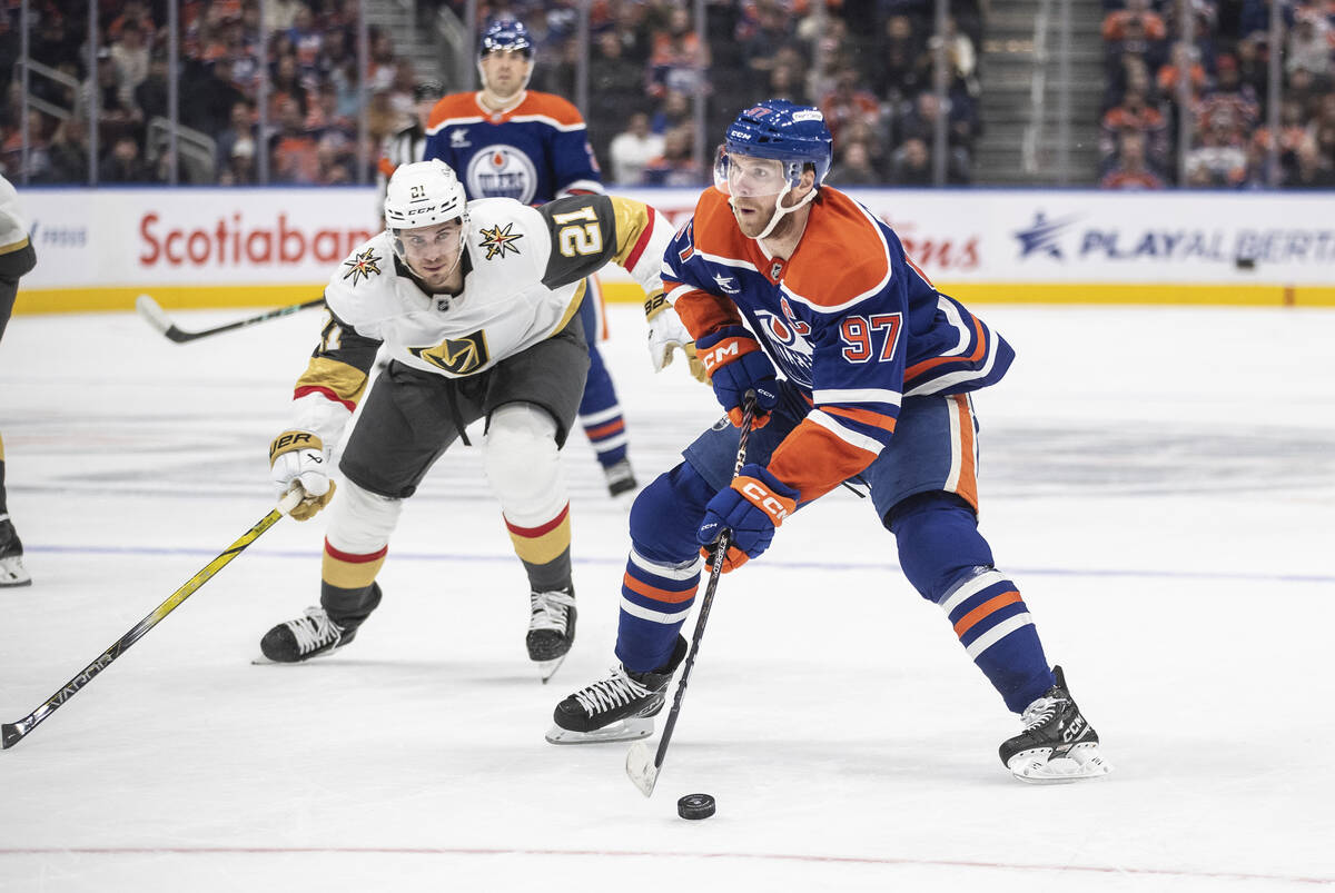 Vegas Golden Knights' Brett Howden (21) chases Edmonton Oilers' Connor McDavid (97) during the ...