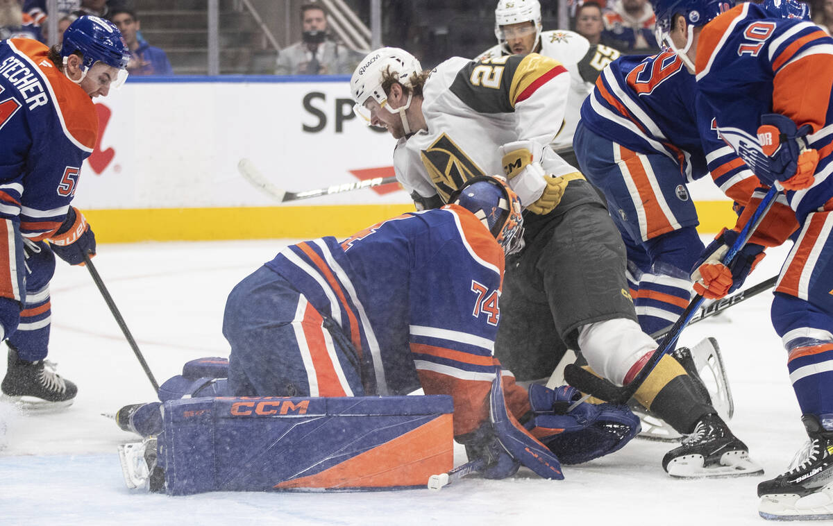 Vegas Golden Knights' Cole Schwindt (22) crashes into Edmonton Oilers goalie Stuart Skinner (74 ...