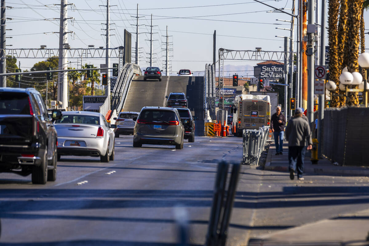 Vehicles navigate the Flamingo bridge and beside it as pedestrians walk along Flamingo Road abo ...