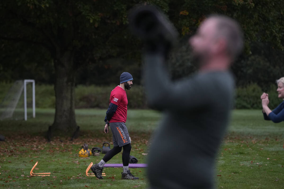 Personal fitness trainer Richard Lamb, leads a group in an outdoor gym class in London, Saturda ...