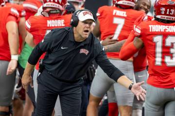 UNLV head coach Barry Odom welcomes players back to the sideline after scoring a touchdown duri ...