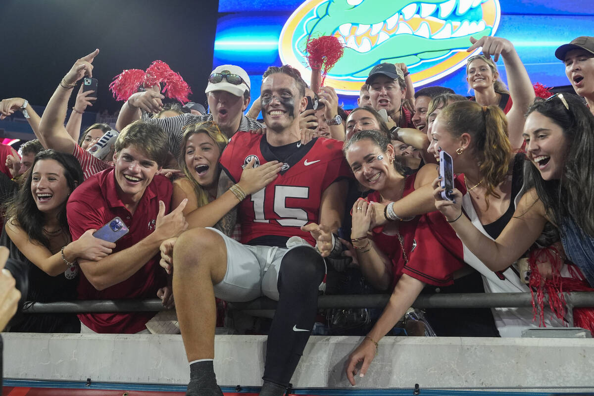 Georgia quarterback Carson Beck, center, celebrates with fans after defeating Florida in an NCA ...