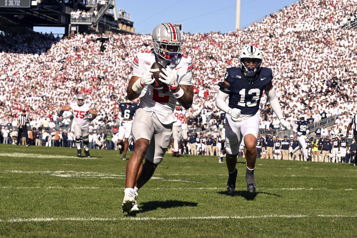 Ohio State wide receiver Emeka Egbuka (2) catches a touchdown pass in front of Penn State lineb ...