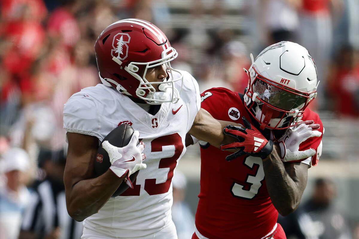 Stanford wide receiver Elic Ayomanor (13) stiff-arms North Carolina State cornerback Aydan Whit ...