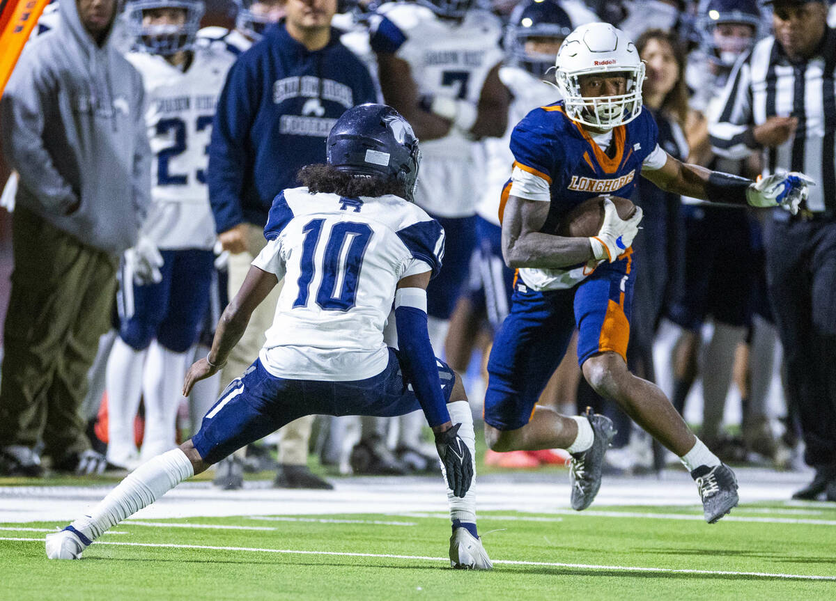 Legacy wide receiver Dominic Oliver (1) secures a catch as Shadow Ridge safety Mujahid Gilliard ...